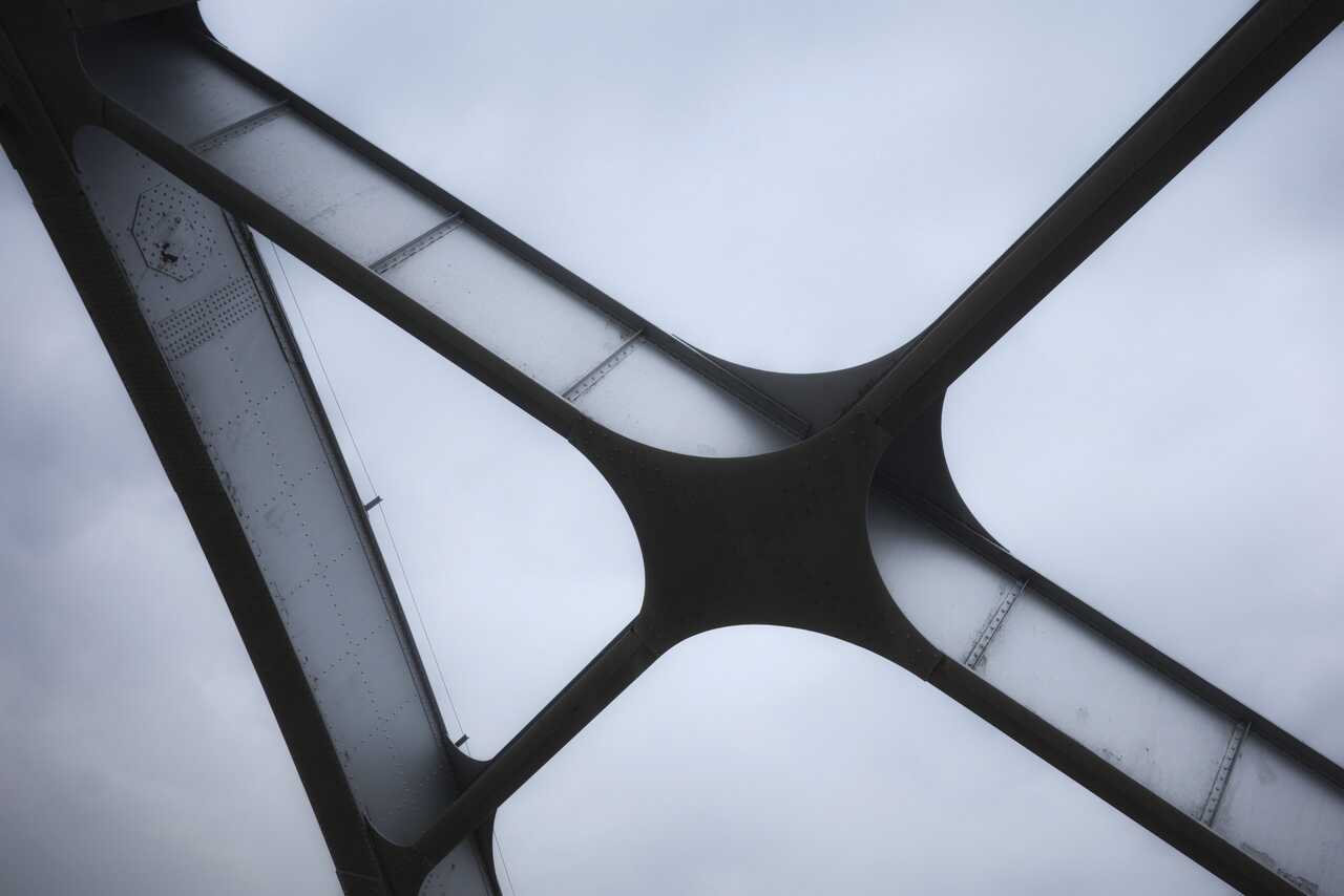 Stahlträger, die sich in einem Knoten vor hellem Himmel kreuzen