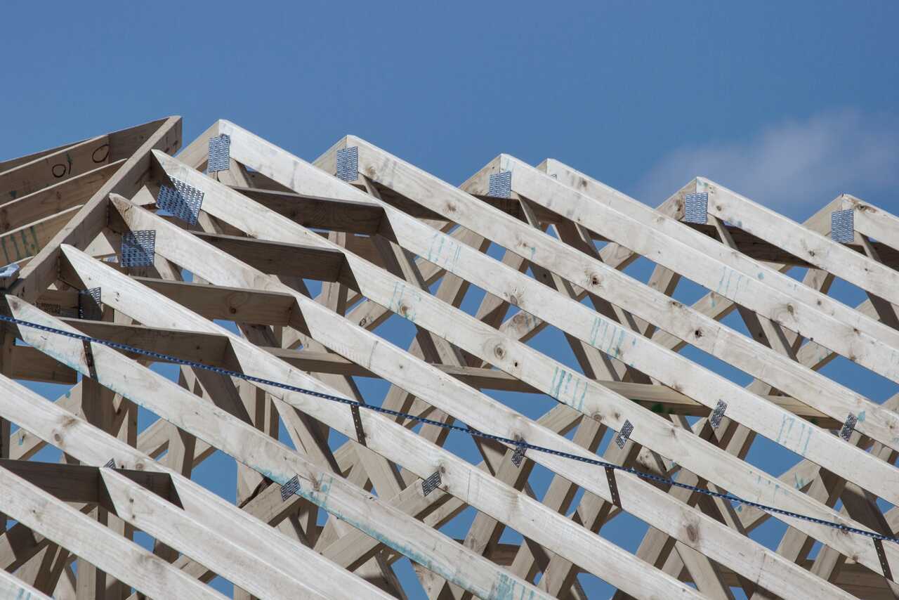 Holzbinder eines Dachstuhls vor blauem Himmel